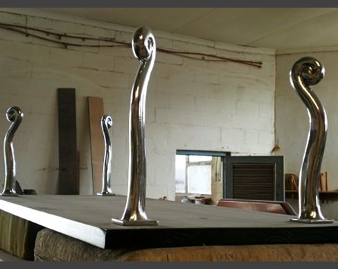 A solid mahogany table top, cut and polished, with Carrol Boyes legs. Mahogany table